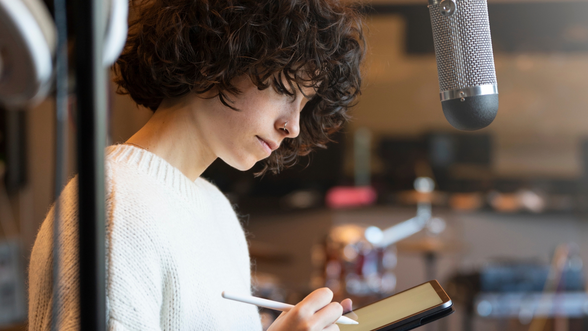 Portada de una chica en un estudio de grabacion que se esta inscribiendo con su tablet en el festival